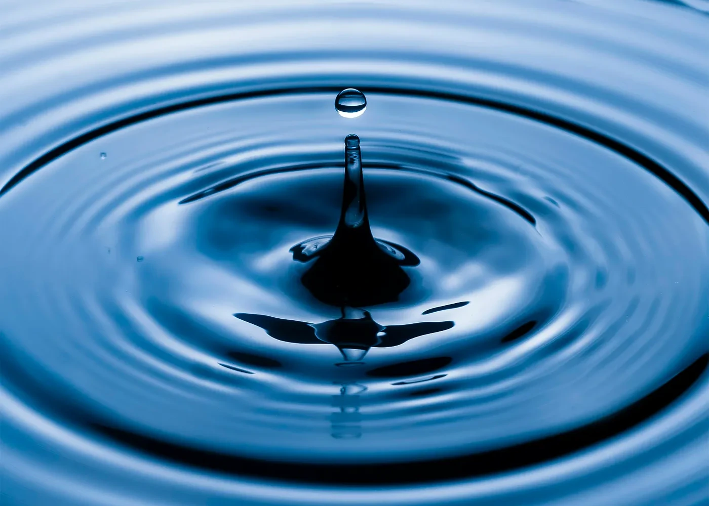 A drop of water falling in a dark sea/puddle