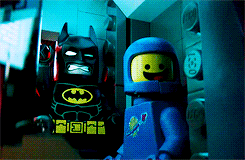 Animated GIF from The Lego Movie showing Lego Batman throwing many batarangs to a button. He misses all but one, then cheerfully announces 'First try!'