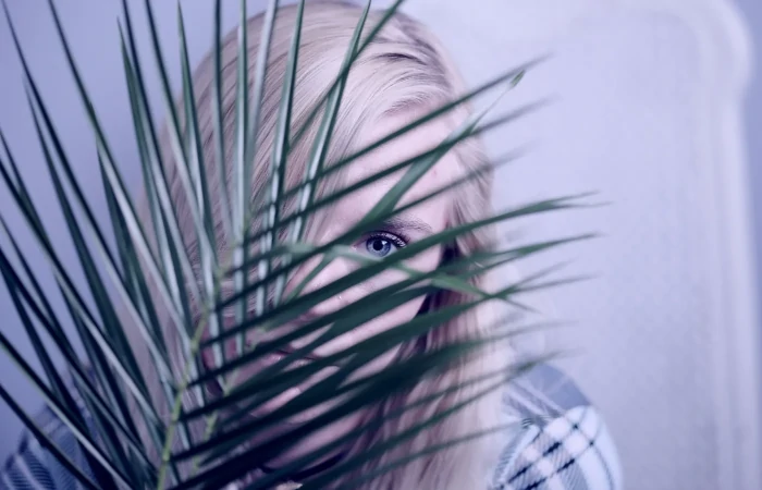 a person hiding behind a plant